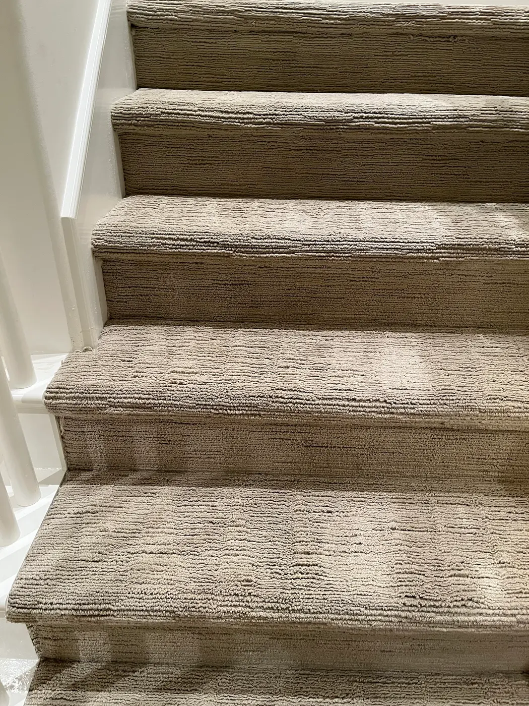 Carpeted stairs, stained treads beside the cleaned stairs after cleaning
