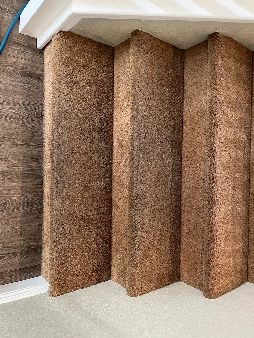 Carpeted stairs, soiled treads beside the cleaned stairs before cleaning