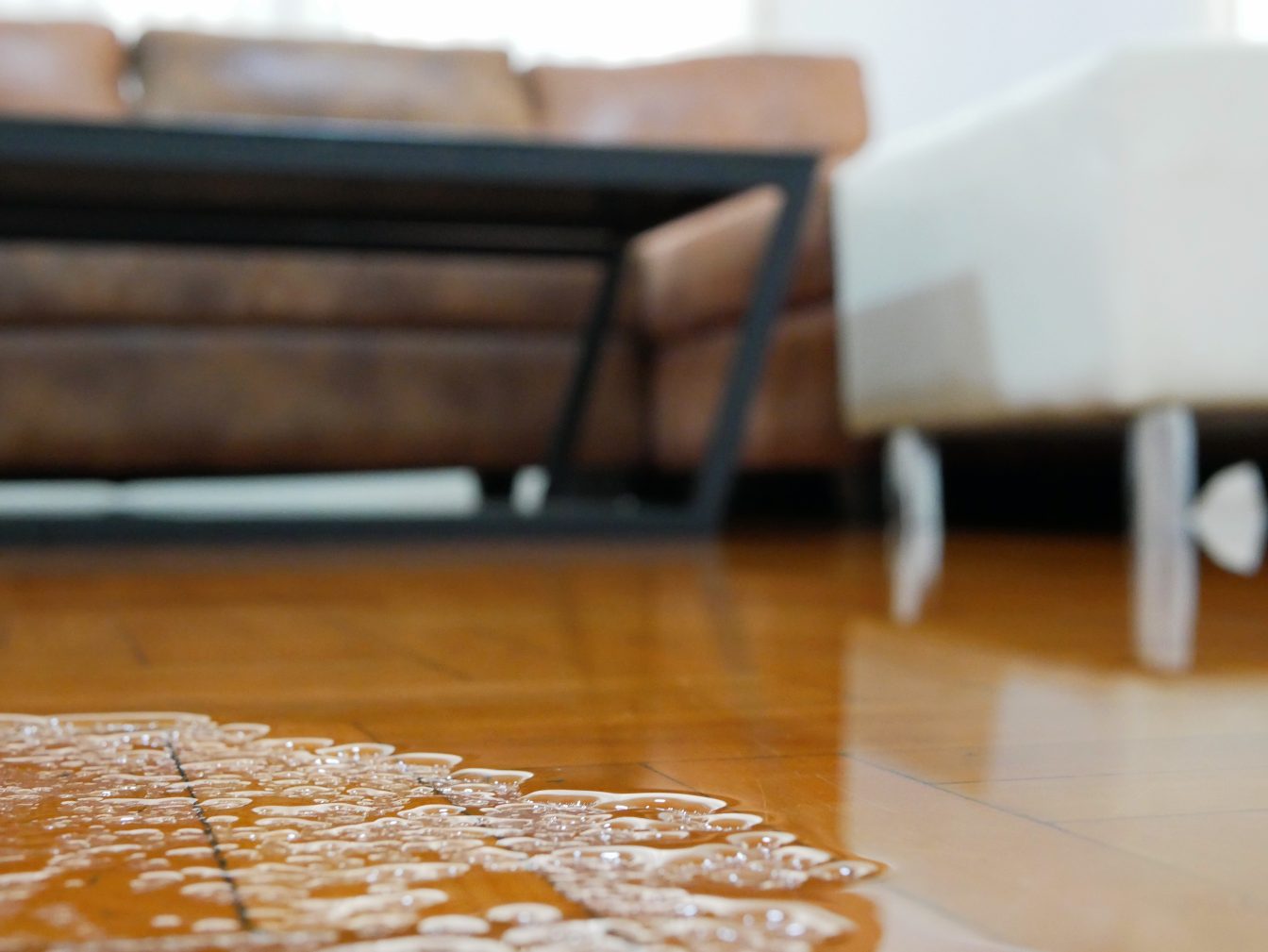 Close up of water flooding on living room parquet floor in a hou